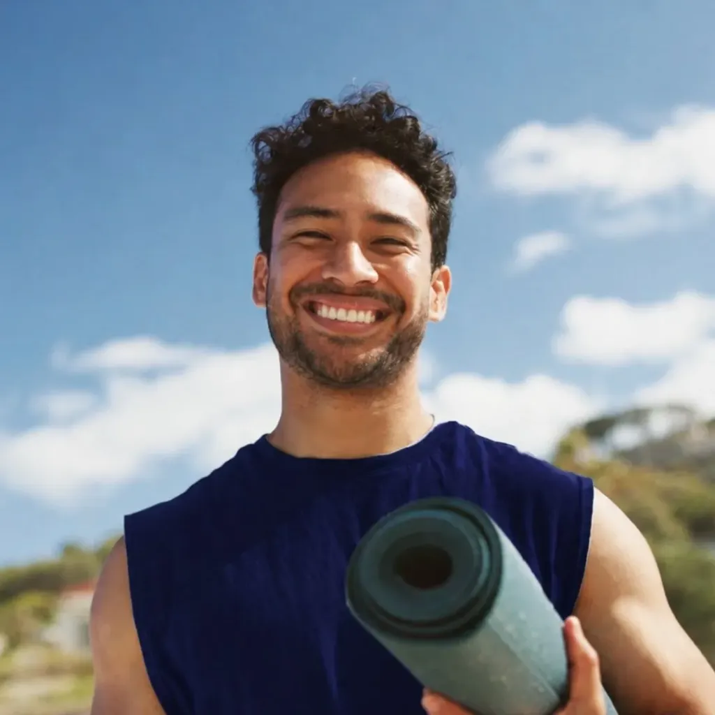 Smiling man outdoors in athletic wear with arms crossed